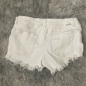 Billabong white shorts with rips in them.